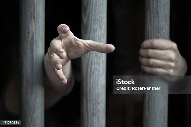 A Person Behind Bars In Prison Stock Photo - Download Image Now - Prison, Christ The Redeemer, Reaching