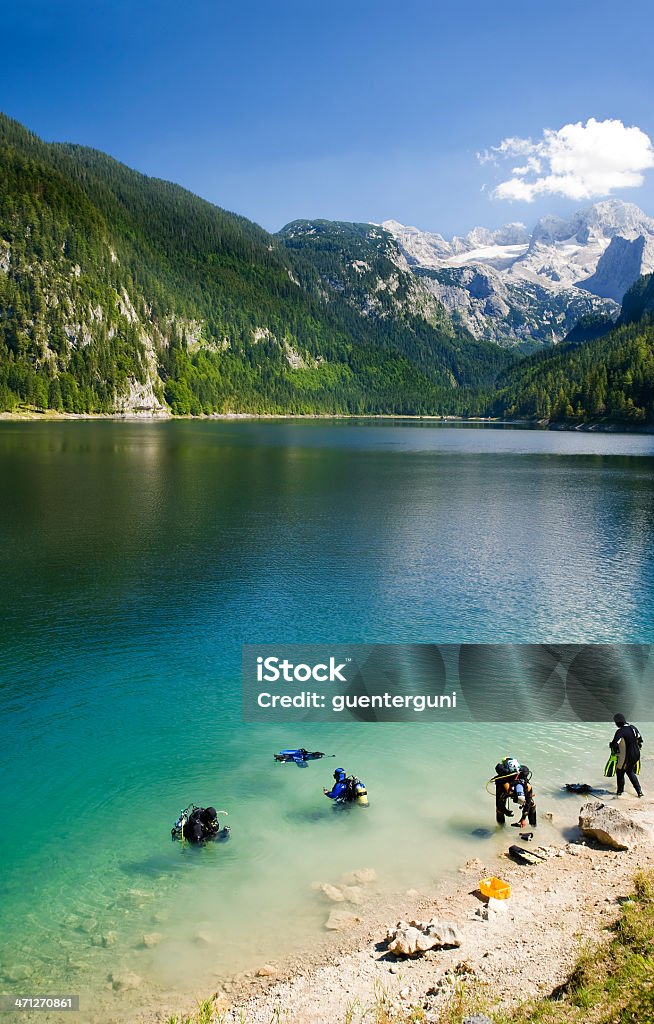 Mergulhadores em um lago alpino, as montanhas e geleiras - Foto de stock de Mergulho Submarino royalty-free