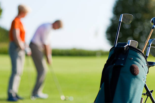 istock Mature couple playing Golf (focus on bag) 471271937