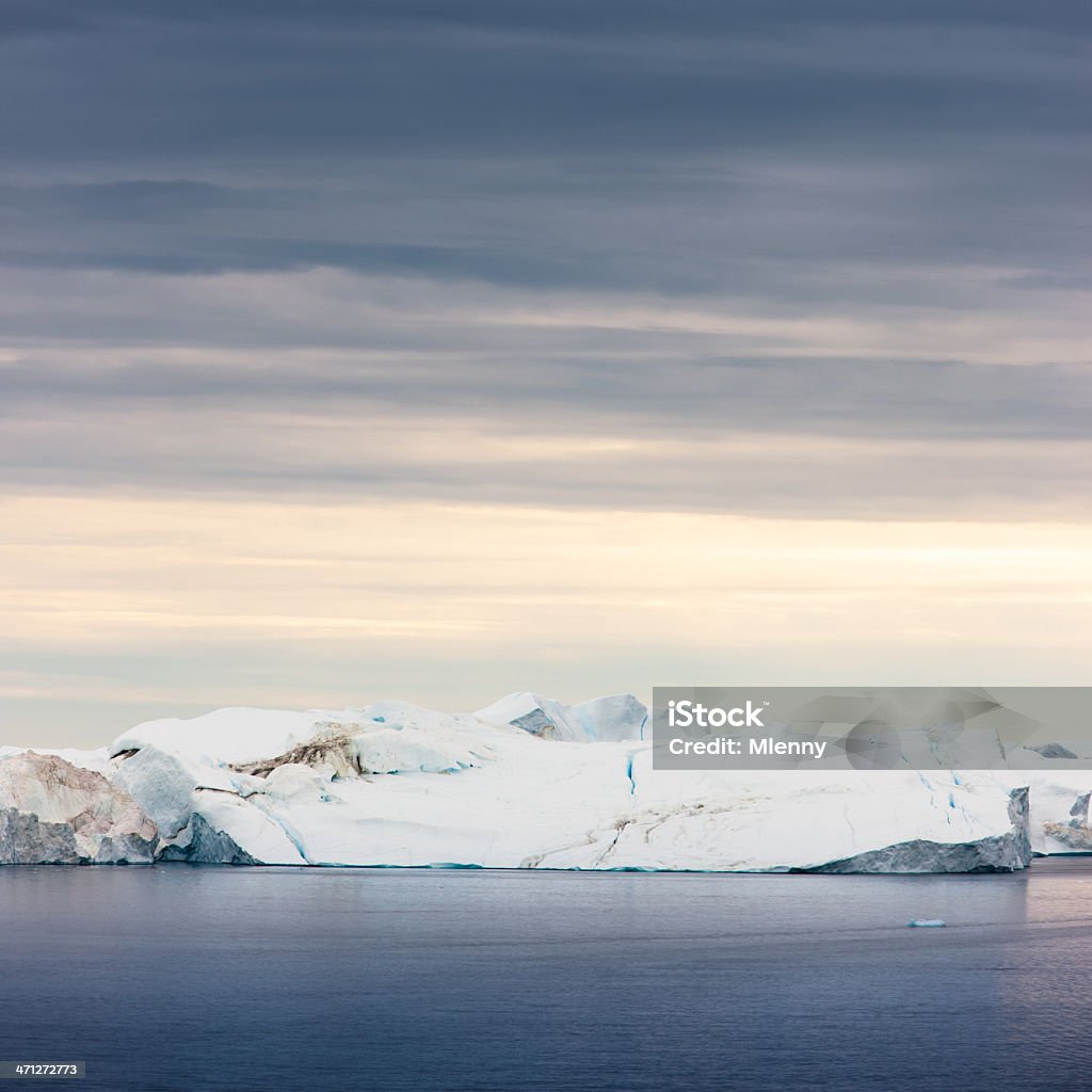 Arctic Sunrise Iceberg Greenland Arctic Sunrise, huge Icebergs in polar arctic waters at the north west greenland coast under moody and colorful sky during sunrise. Greenland, North West Coast. Arctic Stock Photo