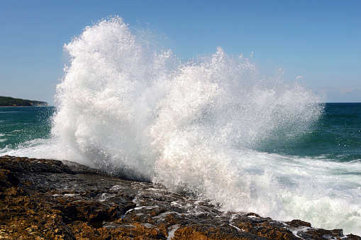 Wave crashing against the beach