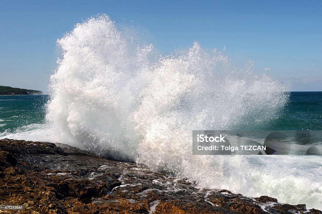 Wave crashing against the beach A huge wave crashes on to the rocks. Splashing Stock Photo