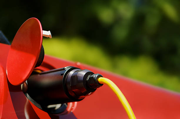 istock Black plug of red electric car recharging 471273701