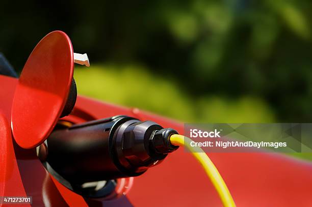 Black Plug Of Red Electric Car Recharging Stock Photo - Download Image Now - Electric Car, Red, Vibrant Color