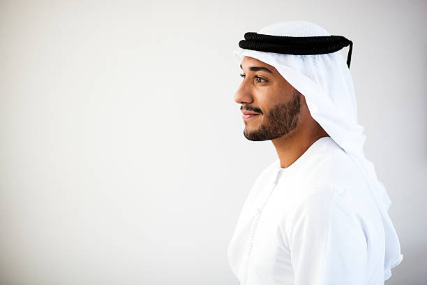 Portrait of a Middle Eastern man smiling to the left Close up portrait of Emirati wearing traditional clothing - kandura, kaffiyeh and agal. united arab emirates stock pictures, royalty-free photos & images