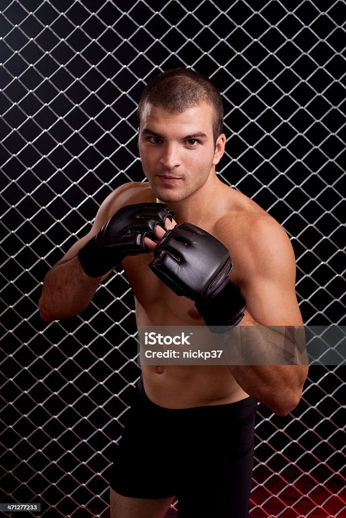 Mixed martial artist posed in front of chain link 20-29 Years Stock Photo