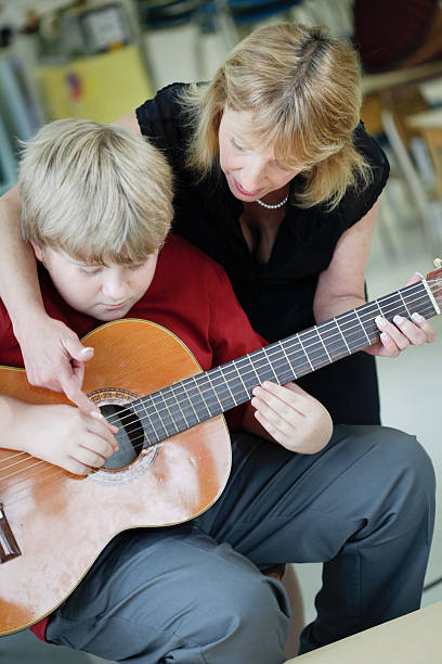 istock Boy Learning to Play Guitar in Music Class 471279309