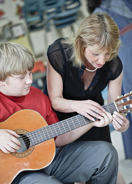 istock Boy Learning to Play Guitar in Music Class 471279443