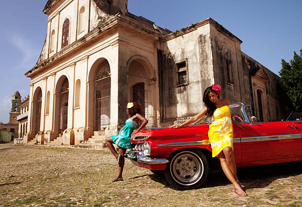 istock Two beautiful women posing with a red car 471280117