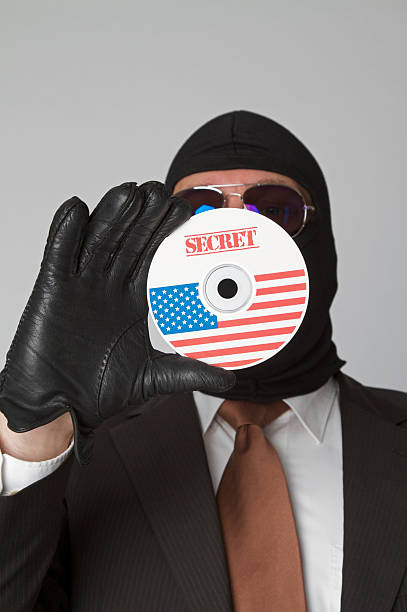 mascherato business uomo di rubare i dati riservati presenti su cd/dvd - business stealing top secret confidential foto e immagini stock