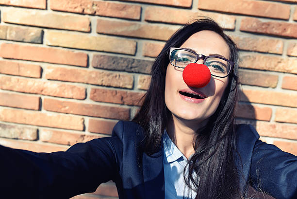 mujer de negocios con nariz de payaso tomando autofoto - curtain red color image clown fotografías e imágenes de stock