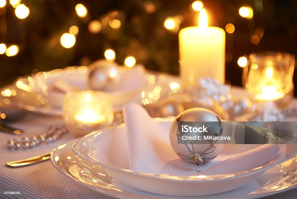 Table for Christmas dinner Table setting with Christmas decorations and Christmas tree in a background. Christmas Stock Photo