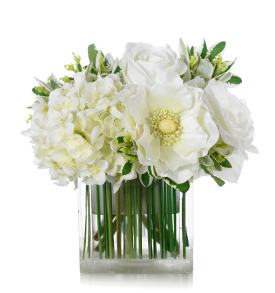 A beautiful arrangement of white roses, hydrangeas and anemones in a decorative 