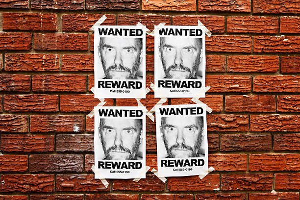 istock Four identical "Wanted" posters taped to a brick wall 471284569