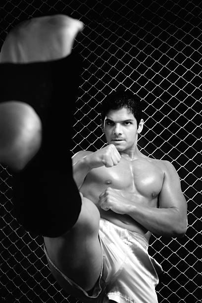 Mixed martial artist posed in front of chain link