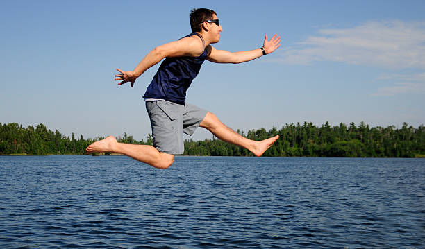 istock Young man running in mid-air by lake, motion blur. 471289101