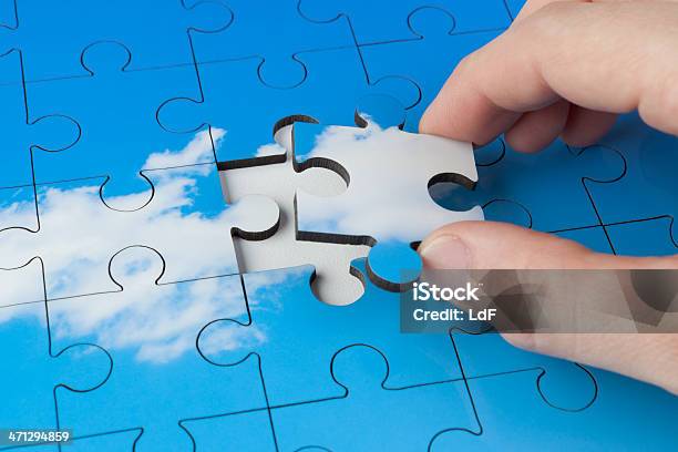 Hand Placing Last Piece Of A Jigsaw Stock Photo - Download Image Now - Jigsaw Puzzle, Cloud - Sky, Abstract