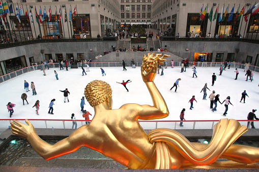 New York, USA - March, 16th 2004: Skaters at the Rockerfeller Centre rink beneath the gilded statue of Prometheus