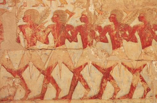 Hieroglyphics depicting farmers during harvest, carrying pitchforks and barley crops.