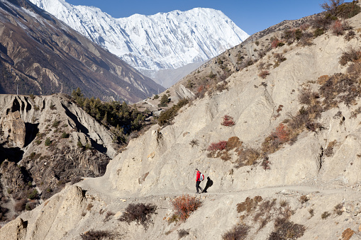 A man on his way to the Tilicho Lake in the Annapurna Conservation Area, Nepal. In the background the snowcapped Tilicho Peak (7.134 mt, 23.400 ft).