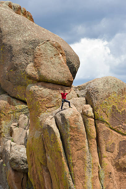 istock Man On Top of Rock Climb Puts Hands in Air 471297737