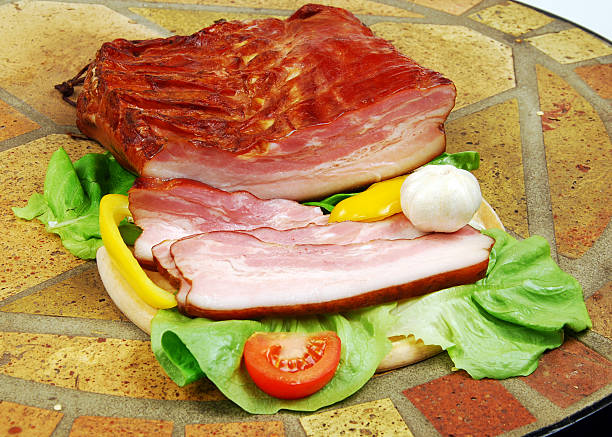 Sliced smoked bacon with wegetables. stock photo