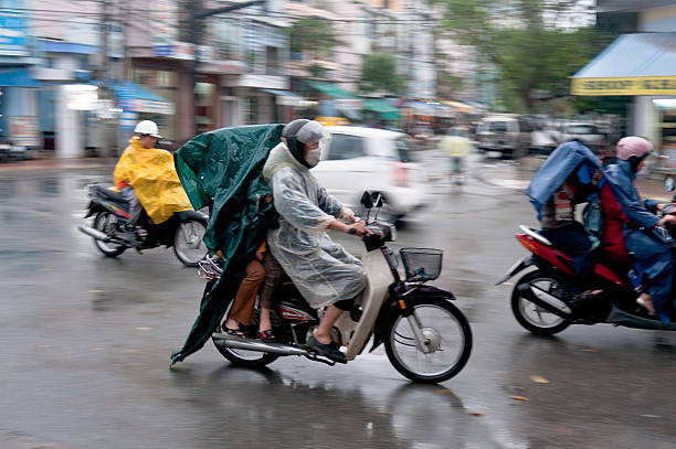 Hanoi, Vietnam - March 30, 2024: Vietnamese man transports boxes of fruit on a motorcycle in Hanoi downtown