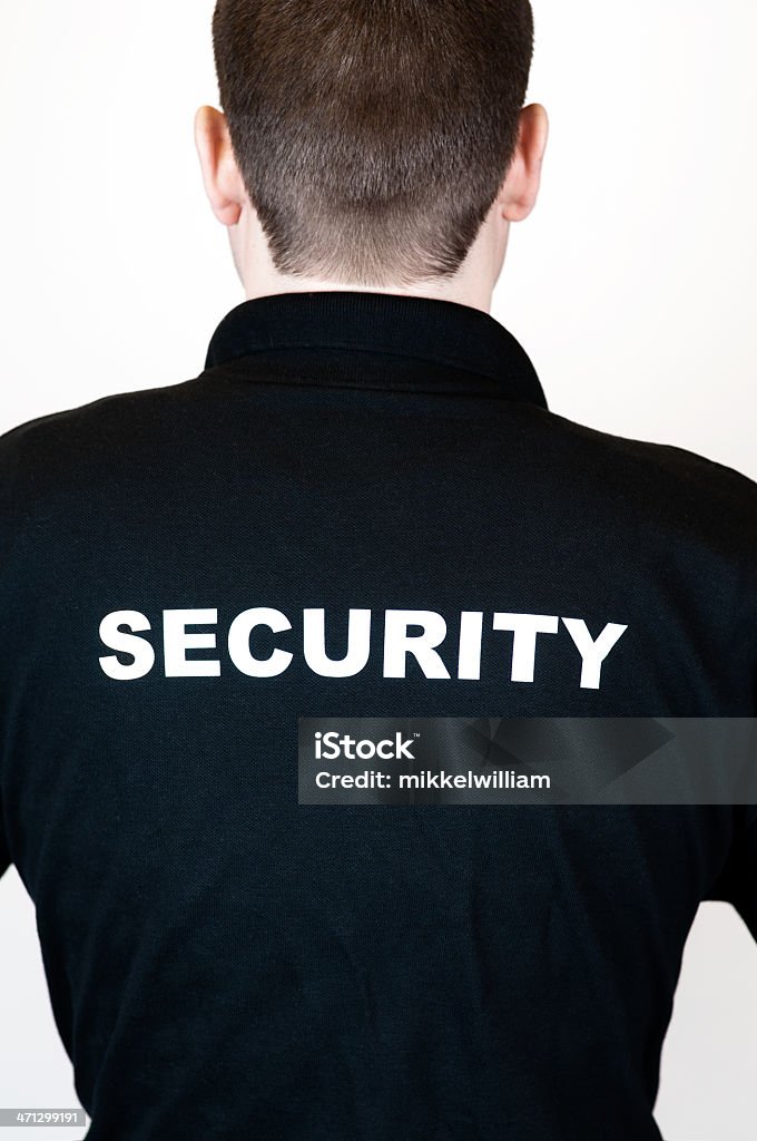 Vista posterior de un agente de seguridad en una camiseta negra - Foto de stock de Guardia de seguridad libre de derechos