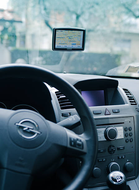 TomTom navigator inside a Opel car Florence, Italy - March 19, 2011: Tom Tom XXL (Europe Version) inside an Opel Zafira car. The gps navigator show the London Map. TomTom is a Dutch company that makes satellite navigation systems for automobiles, motorcycles, handhelds and smartphones. It is the leading supplier of navigation systems in Europe with offices around the world. guidanc stock pictures, royalty-free photos & images