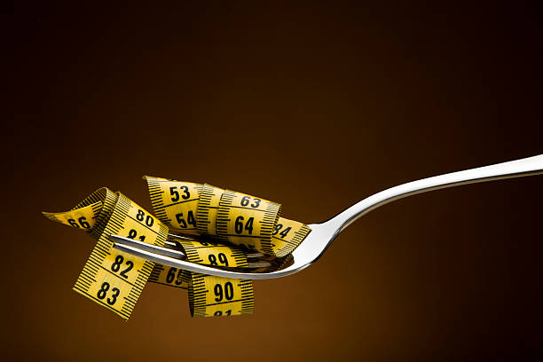 conceito de dieta - healthy eating fork tape measure still life - fotografias e filmes do acervo