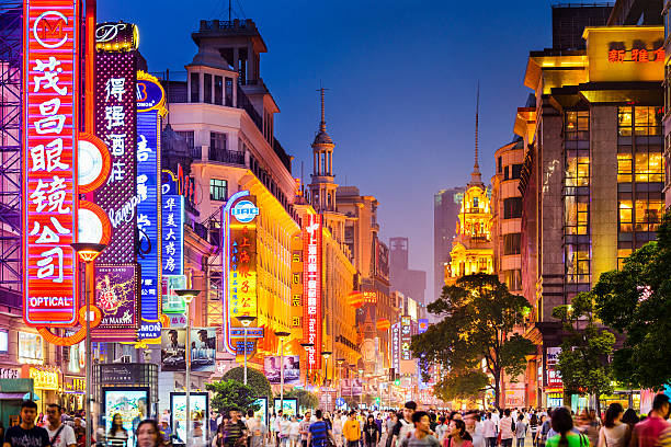 Shoppping Street in Shanghai Shanghai, China - June 20, 2014: Crowds walk below neon signs on Nanjing Road. The street is the main shopping district of the city and one of the world's busiest shopping districts. jiangsu province photos stock pictures, royalty-free photos & images