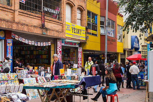 Bogota, Colombia - March 26, 2015: Street vendors on Calle or Street 16. Some of them are selling second-hand books.  This section of the street is closed to vehicular traffic and is an all pedestrian street.  Photo shot in the early afternoon sunlight; horizontal format.