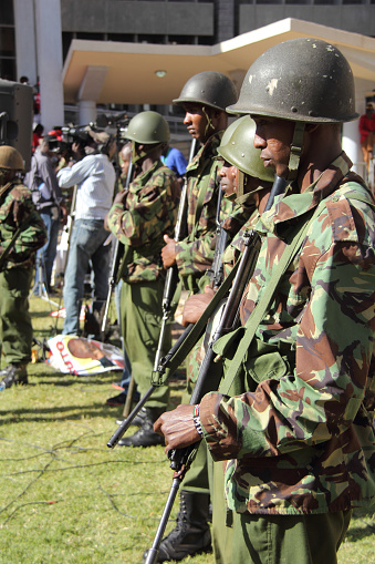 Nairobi, Kenya- March 19, 2013: Heavily armed Kenyan military personal wait outside the Catholic University as President Uhuru Kenyatta gives his acceptance speech.