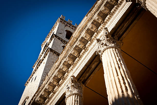Temple of Minerva and Torre del Popolo The columns of the Temple of Minerva, under "Torre del Popolo" in Assisi. umbria architecture assisi corinthian stock pictures, royalty-free photos & images