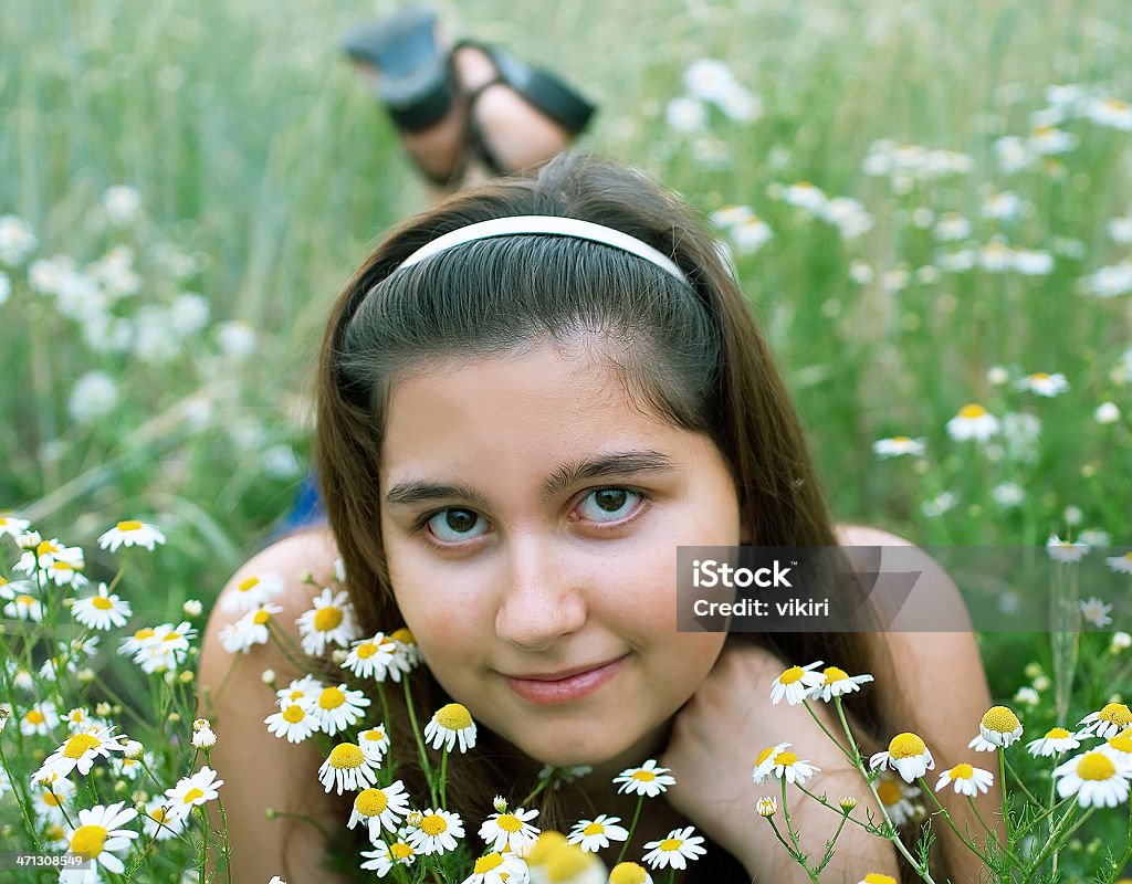 girl on chamomiles Young girl on chamomiles field. Shallow DOF Agricultural Field Stock Photo