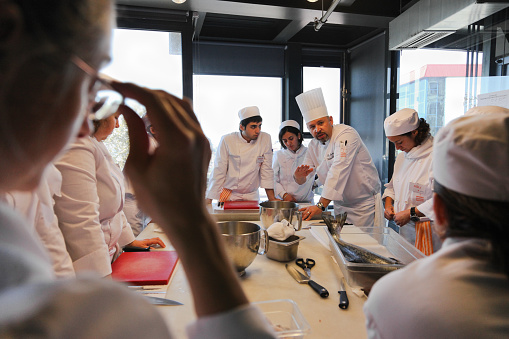Istanbul, Turkey - November 5, 2009: Chef Instructor Fehmi Samanco and students  during a lesson of the Istanbul Culinary Institute. Istanbul Culinary Institute is an educational and vocational center dedicated to the research, teaching and promotion of Turkish and Mediterranean cuisines.