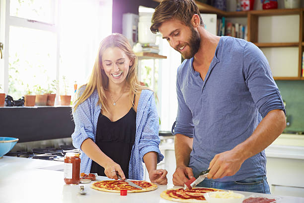 istock Young Couple Making Pizza In Kitchen Together 471311268