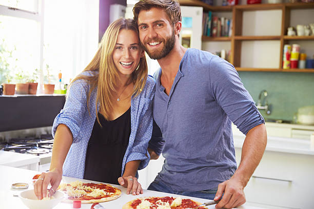 istock Young Couple Making Pizza In Kitchen Together 471311300