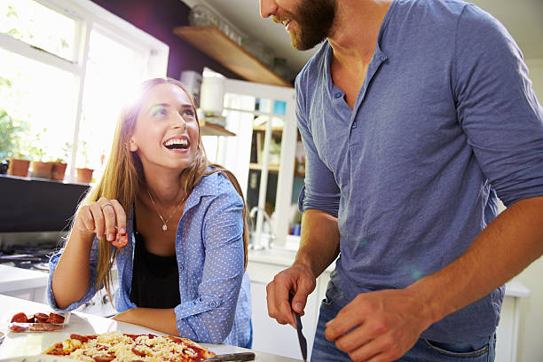 istock Young Couple Making Pizza In Kitchen Together 471311302