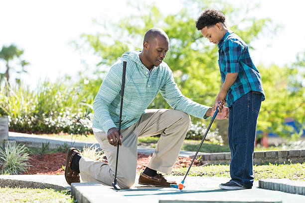 Father and son playing miniature golf