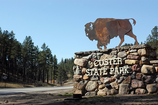 Custer, South Dakota, USA - March 24th 2004: The entrance gate and sign with a Bison emblem to Custer State Park in South Dakota