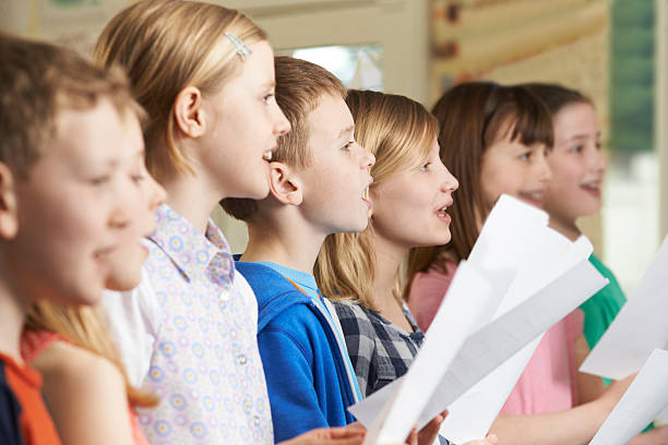 grupy dzieci w szkole śpiewać w szkole chór - singing lesson zdjęcia i obrazy z banku zdjęć