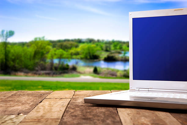 istock Landscape background with blank laptop on wooden table. 471314332