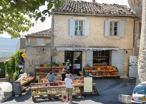 Gordes, France - July, 4th 2007:A classic village fruit and vegetable store with customers in the Provence region of France