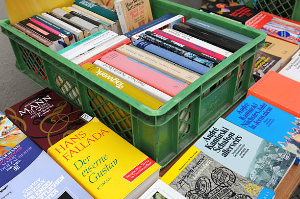 Berlin, Germany - August 3, 2011: used bookstore at Berlin Kreuzberg (Germany) at Bergmannstrasse. in front old second hand book waiting for buyers like Fairytales of Hand Fallada, or book of Thomas Mann. Its a touristical magnet of multi-culture.