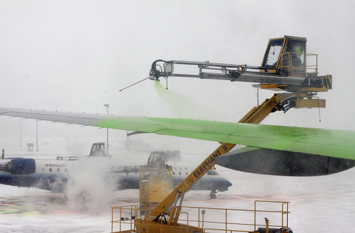 Missisauga, Canada, March 23, 2011: De-icing vehicles spraying fluid on airplace in Airport 