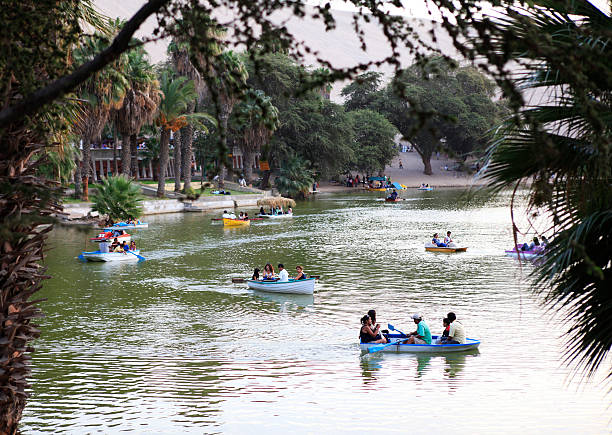 persone andare in barca su huacachina oasi - editorial in a row national landmark famous place foto e immagini stock