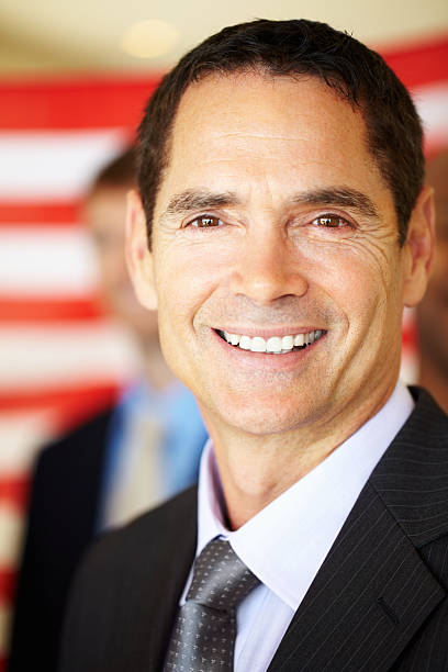 istock Attractive executive smiling with flag in the background 471319447