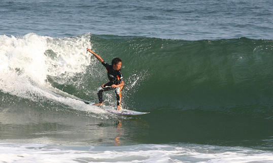 Sendai, Japan - October, 2nd, 2004: A japanese enthusiast riding a giant wave on the Sendai beach near Natori.