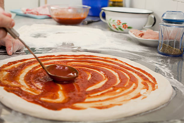 Chef preparing homemade pizza in the kitchen.